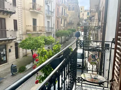 a table and chairs on a balcony with a view of a balcony at I MORI - Holiday Rooms in Lascari