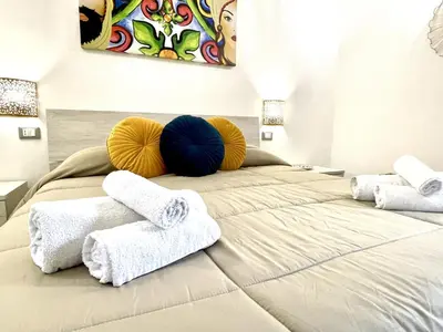 a bedroom with a bed with towels on it at I MORI - Holiday Rooms in Lascari