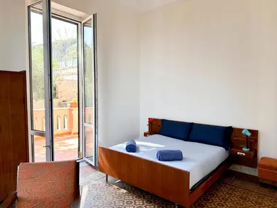 a bedroom with a bed and a large window at Casa Stella Splendida Villa sul Mare in Palermo