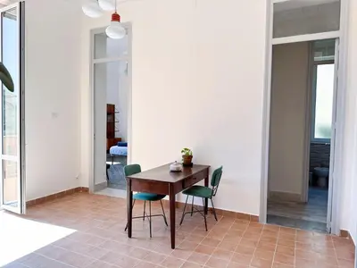a dining room with a wooden table and green chairs at Casa Stella Splendida Villa sul Mare in Palermo