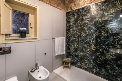 a bathroom with a black and white patterned wall at Vintage Rooms in Palermo