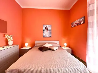 a bedroom with orange walls and a bed with two lamps at Domus Aurea in Isola delle Femmine