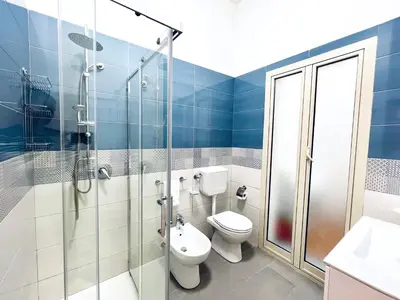 a bathroom with a toilet and a glass shower at Domus Aurea in Isola delle Femmine