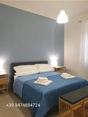 a bedroom with a blue bed with two towels on it at CasALE Sampó in Palermo