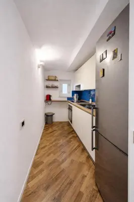 a kitchen with a refrigerator and a wooden floor at Palazzo Moncada appartamento 2 in Palermo