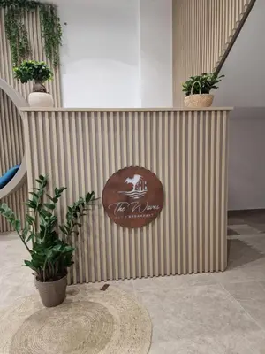 a sign on a wall with potted plants on it at The waves in Terrasini