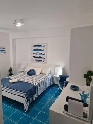 a bedroom with a bed with a blue floor at The waves in Terrasini