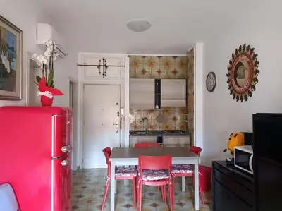 a kitchen with a table and chairs and a red refrigerator at Mondello Ashur Margot House in Palermo
