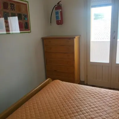 a bedroom with a bed and a dresser and a window at Mondello Ashur Margot House in Palermo