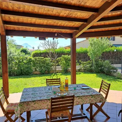 a table and chairs under a wooden pergola at PTA Appartavilla in Campofelice di Roccella