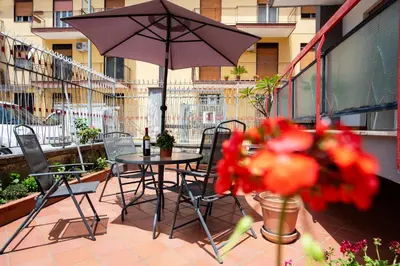 a patio with a table and chairs and an umbrella at Gardenia Home in Palermo