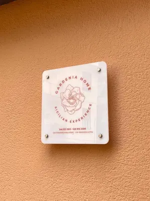 a sign on a wall with a flower on it at Gardenia Home in Palermo