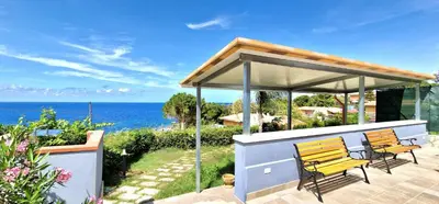 a gazebo with two chairs and the ocean at Casa Richilde in Scopello