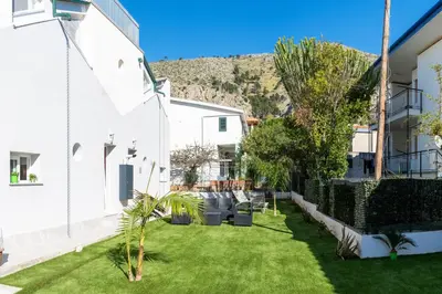 a courtyard in a building with grass and plants at 3B Mondello Apartments in Palermo