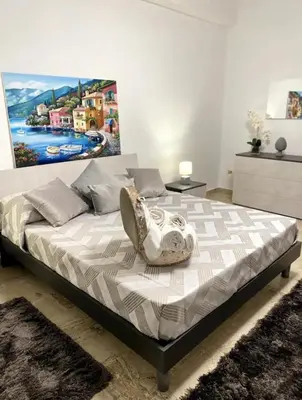 a bedroom with a bed with a painting on the wall at Cusumano house in Trappeto