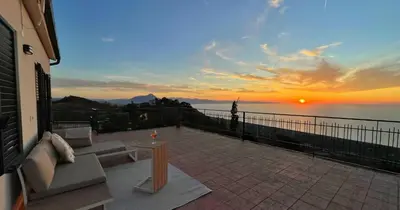 a view of a sunset from a patio with a table at Il Poggio Retreat - Cefalù in Cefalù