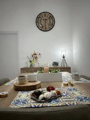 a living room with a table with a clock on the wall at Appartamento Olivuzza House in Palermo