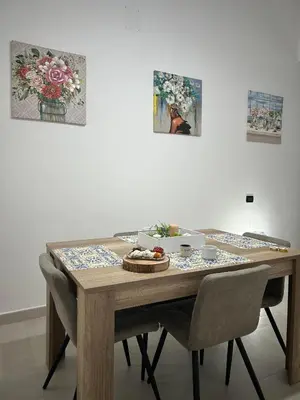 a wooden table with chairs and a plate of food on it at Appartamento Olivuzza House in Palermo