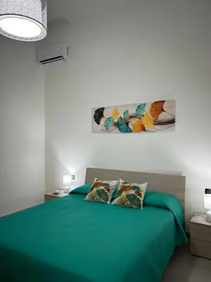 a bedroom with a green bed with two pillows at Appartamento Olivuzza House in Palermo
