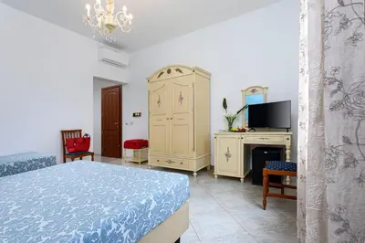 a hotel room with two beds and a television at Araba Fenice Hotel in San Vito lo Capo