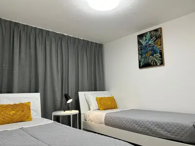 a bedroom with two beds and a window with curtains at Matteotti35 in Terrasini