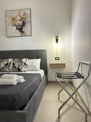 a bedroom with a bed and a chair in it at Matteotti35 in Terrasini