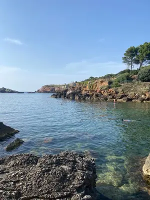 a body of water with rocks and people in the water at SinyHouse in Terrasini