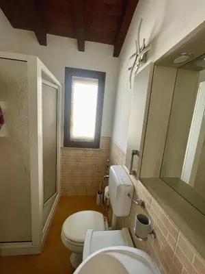 a bathroom with a toilet and two sinks and a window at SinyHouse in Terrasini