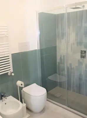 a bathroom with a shower and a toilet and a sink at Villa Mercurio Mondello in Mondello