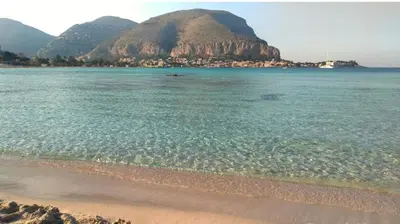 a view of a beach with a mountain in the background at Villa Mercurio Mondello in Mondello