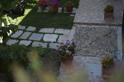 a garden with potted plants and flowers on the ground at Baglio Buccellato in Scopello