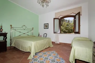 a bedroom with two beds and a window at Baglio Buccellato in Scopello