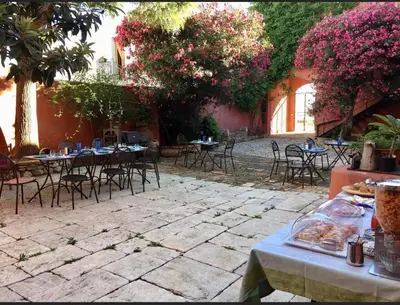 an outdoor patio with tables and chairs and flowers at Baglio Buccellato in Scopello