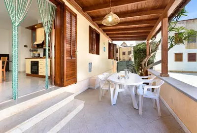 a patio with a white table and chairs on it at Casa Karuscia in San Vito lo Capo