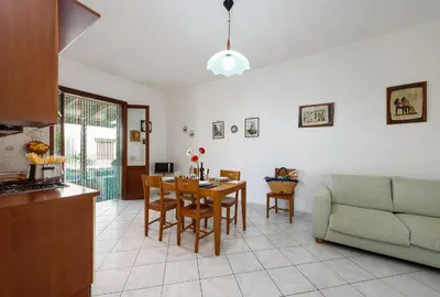 a kitchen and living room with a table and a couch at Casa Karuscia in San Vito lo Capo