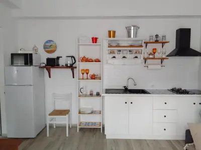 a kitchen with white cabinets and a white refrigerator at La casetta di rosario mondello in Palermo
