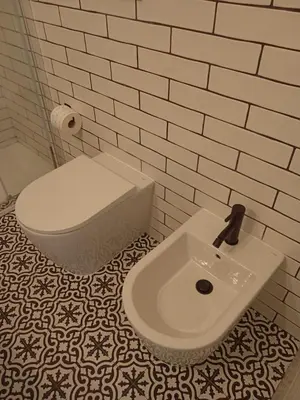 a bathroom with a white toilet and a sink at La casetta di rosario mondello in Palermo