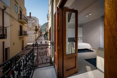 a door to a balcony with a view of a street at La suite del Golfo in Castellammare del Golfo