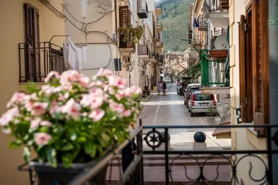 a view of a street with pink flowers on a balcony at La suite del Golfo in Castellammare del Golfo