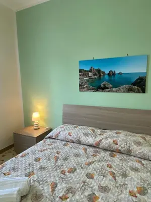 a bedroom with a bed and a painting on the wall at Villa L'orizzonte di calabianca in Castellammare del Golfo