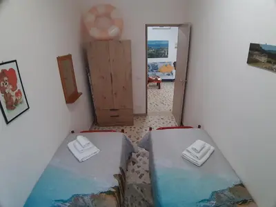 a view of a room with two beds and a doorway at Villa L'orizzonte di calabianca in Castellammare del Golfo