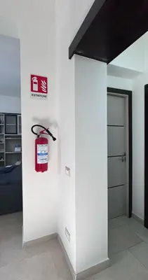 a room with a white wall with a fire extinguisher at Casa Graziella Vacanze in Palermo