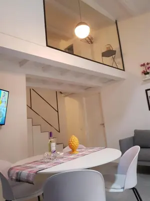 a dining room with a white table and chairs at appartamento politeama in Palermo