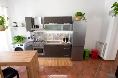 a kitchen with a stainless steel refrigerator and a table at Pothos House in Palermo