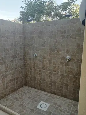 a bathroom with a shower with a stone wall at Residence Mare Azzurro in Balestrate