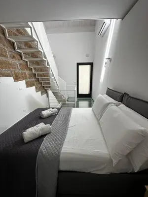 a bedroom with a bed and a stair case at Le Gemelle Diverse in Cinisi