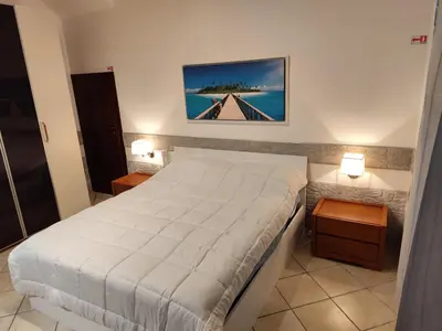 a bedroom with a bed and two night stands at La Casetta Nell' Atrio Cavalieri in Bagheria