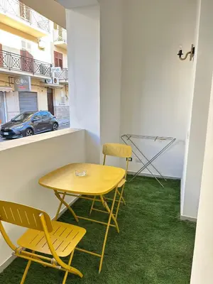 a table and chairs in a room with grass at I Faraglioni Comfort Rooms in Terrasini