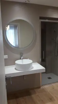 a bathroom with a white sink and a mirror at I Faraglioni Comfort Rooms in Terrasini