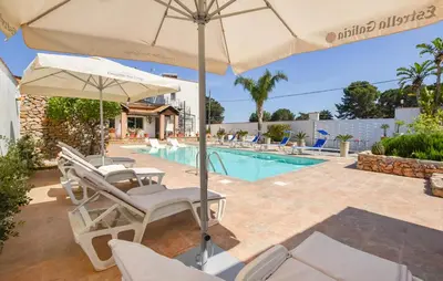a patio with chairs and an umbrella and a pool at Gorgeous Home In Terrasini in Terrasini